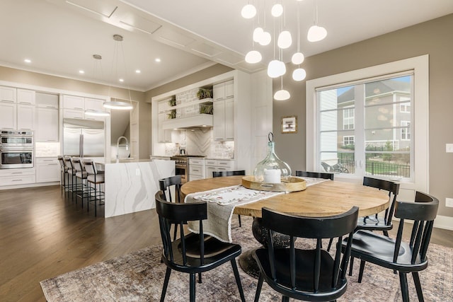 dining room with recessed lighting, dark wood-type flooring, and crown molding
