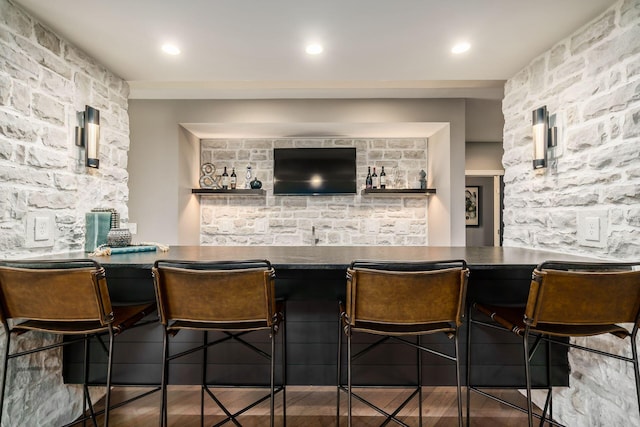 bar featuring a community bar, recessed lighting, and wood finished floors