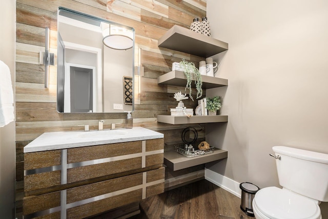 bathroom with baseboards, a sink, toilet, and wood finished floors