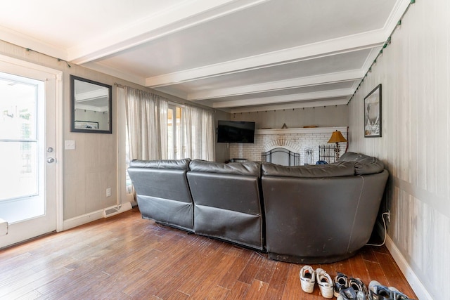 living room with plenty of natural light, beamed ceiling, and hardwood / wood-style flooring