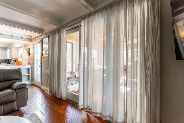 living room featuring beamed ceiling, hardwood / wood-style floors, and crown molding