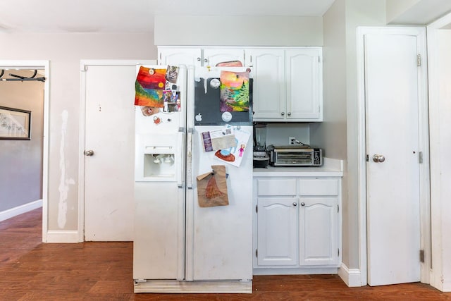 kitchen featuring white cabinets, dark hardwood / wood-style floors, and white refrigerator with ice dispenser