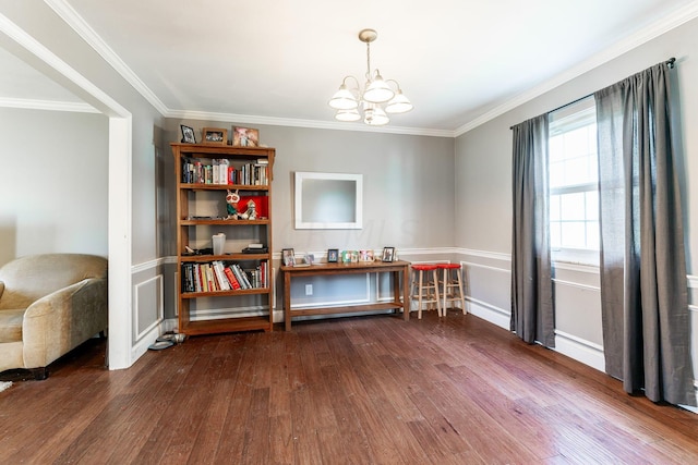 living area featuring dark hardwood / wood-style flooring, a chandelier, and ornamental molding