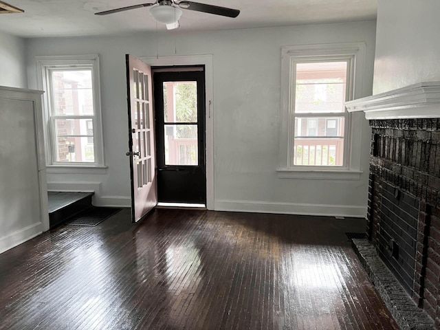 entryway featuring dark hardwood / wood-style floors, a healthy amount of sunlight, a fireplace, and ceiling fan