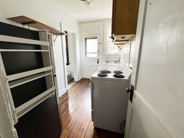 kitchen featuring dark wood-type flooring, electric stove, sink, decorative backsplash, and white fridge