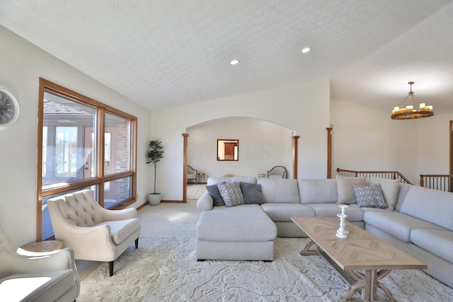 carpeted living room featuring a textured ceiling, a chandelier, and lofted ceiling