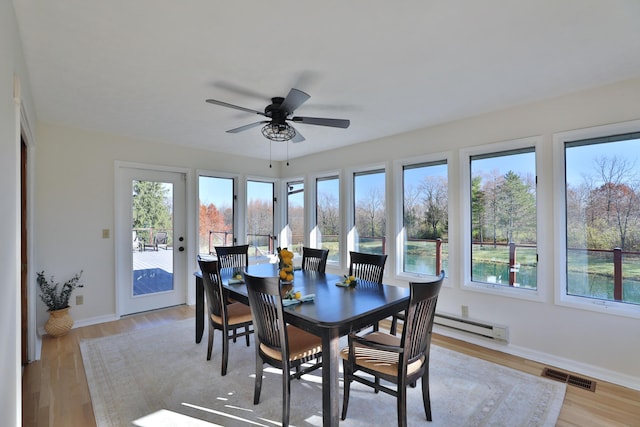 sunroom / solarium with ceiling fan and baseboard heating