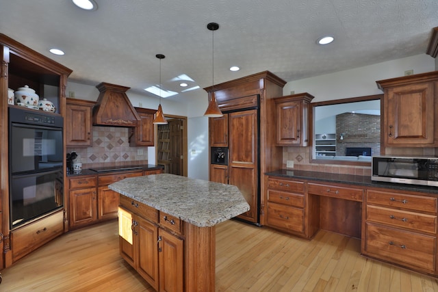 kitchen with a center island, black appliances, tasteful backsplash, decorative light fixtures, and light hardwood / wood-style floors