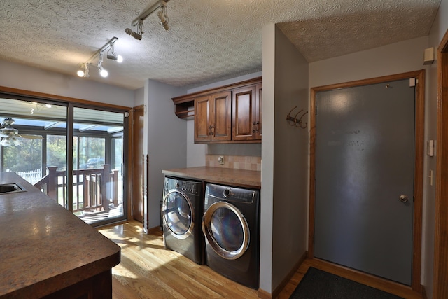 clothes washing area featuring a textured ceiling, separate washer and dryer, track lighting, and light wood-type flooring