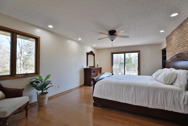 bedroom featuring a textured ceiling, light wood-type flooring, and ceiling fan