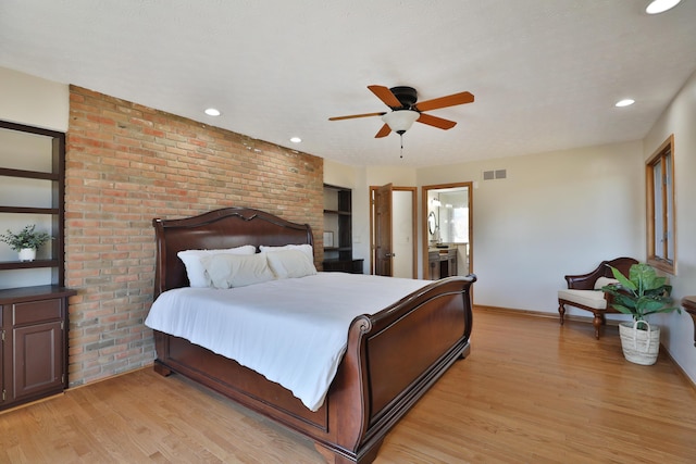 bedroom featuring ceiling fan, ensuite bath, and light hardwood / wood-style flooring