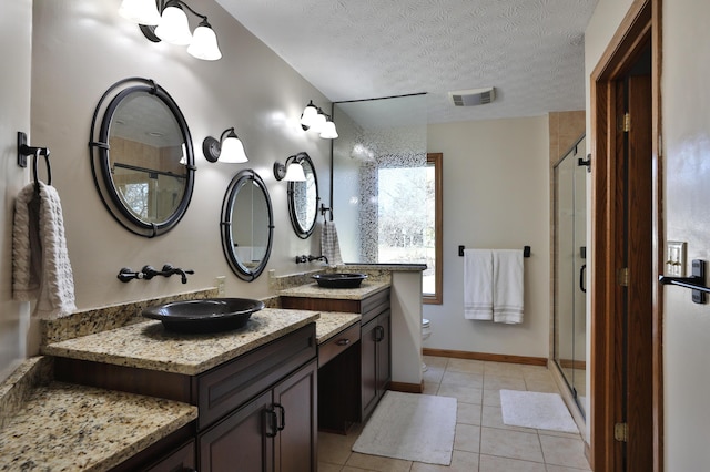 bathroom with vanity, a textured ceiling, tile patterned flooring, toilet, and a shower with shower door