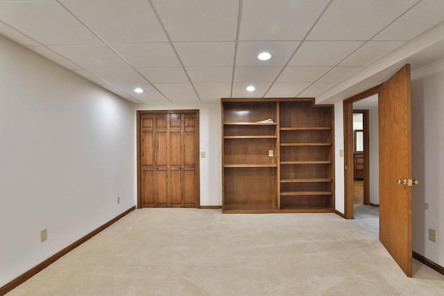 unfurnished bedroom with a drop ceiling and light colored carpet