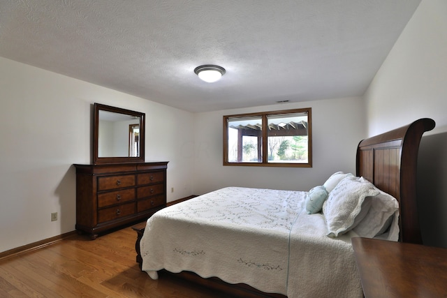 bedroom featuring a textured ceiling and hardwood / wood-style flooring