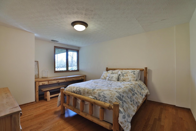 bedroom featuring a textured ceiling and hardwood / wood-style flooring