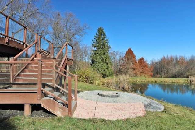 view of yard with a deck with water view and an outdoor fire pit