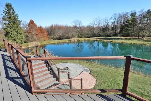 deck with a patio area, a water view, a yard, and an outdoor fire pit