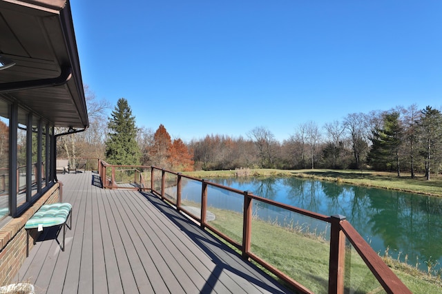 wooden terrace featuring a water view and a lawn