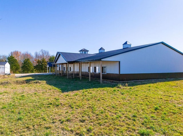 back of property with a storage shed and a yard