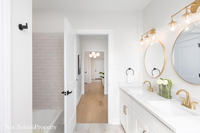 bathroom with a bathing tub, hardwood / wood-style floors, and vanity