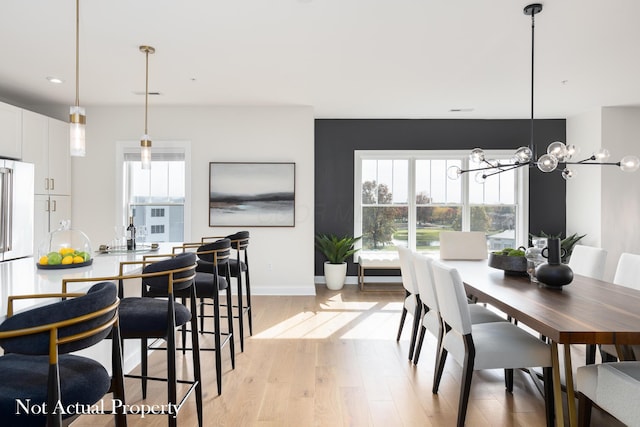 dining room with a chandelier, light hardwood / wood-style flooring, and a wealth of natural light