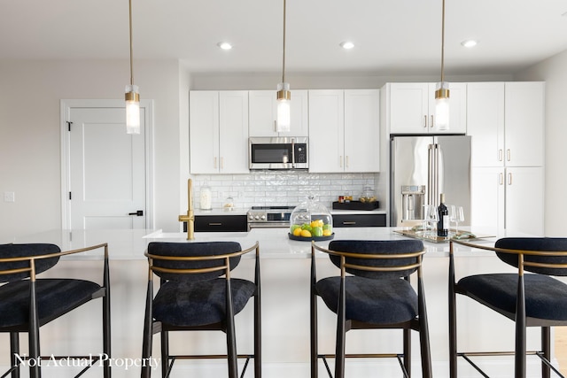 kitchen featuring white cabinetry, stainless steel appliances, hanging light fixtures, and tasteful backsplash