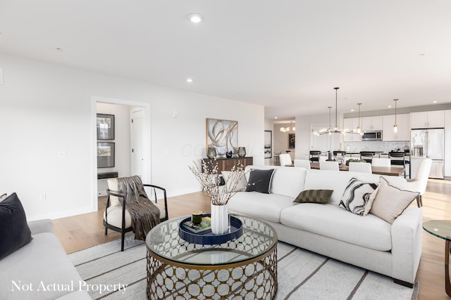 living room featuring a chandelier and light hardwood / wood-style flooring