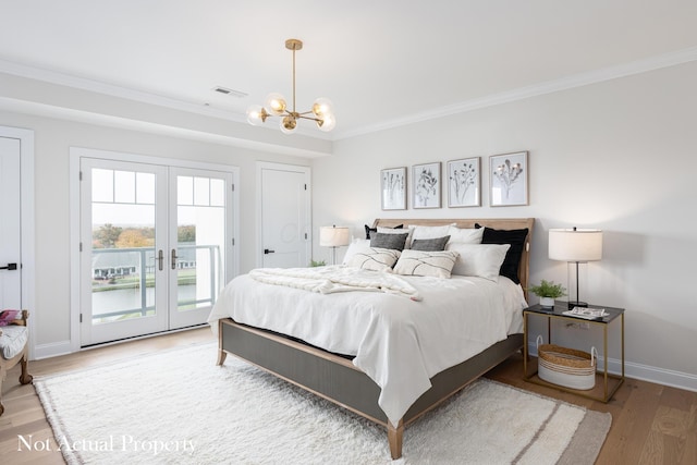 bedroom featuring french doors, ornamental molding, access to outside, hardwood / wood-style flooring, and a notable chandelier