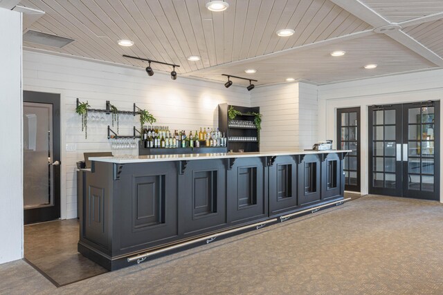 bar with dark colored carpet, french doors, and wooden ceiling