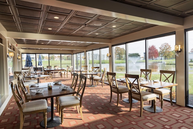 sunroom / solarium featuring plenty of natural light and a water view