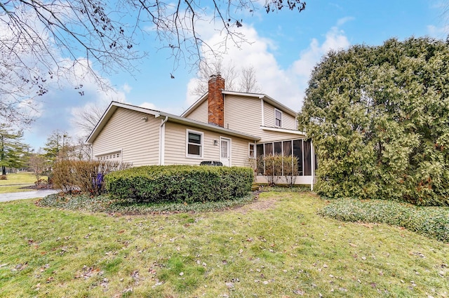 rear view of property featuring a yard and a sunroom