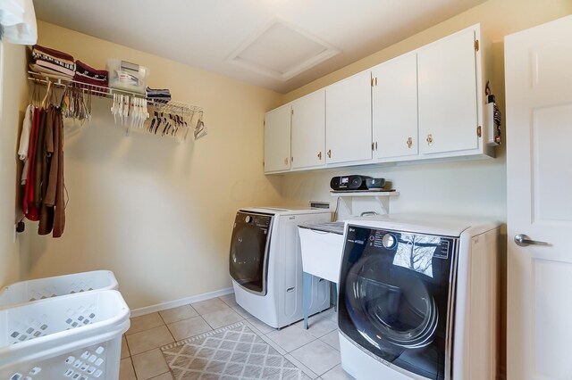 clothes washing area with cabinets, light tile patterned floors, and independent washer and dryer