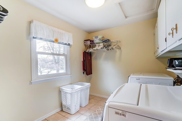 laundry room with cabinets, washing machine and dryer, and light tile patterned floors