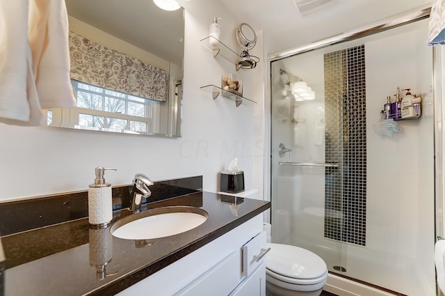 bathroom featuring vanity, toilet, and an enclosed shower