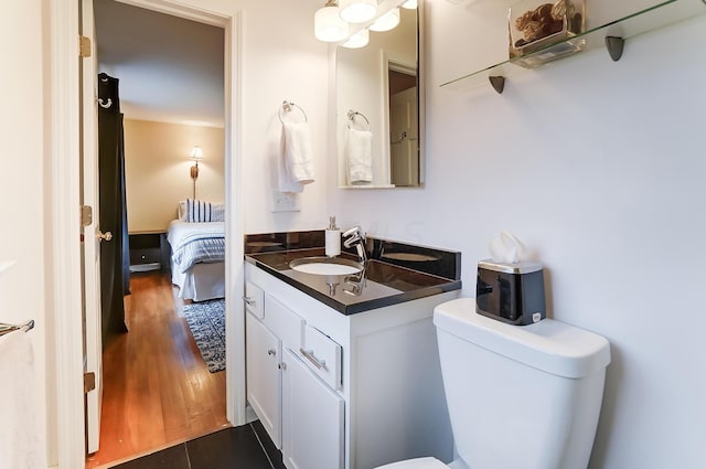 bathroom with hardwood / wood-style flooring, vanity, and toilet