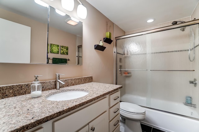 full bathroom with vanity, combined bath / shower with glass door, and toilet