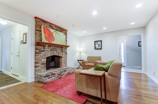 living room with a fireplace and light wood-type flooring