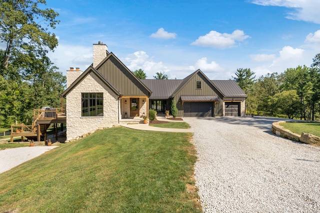 view of front of property featuring a garage, a front lawn, and a deck