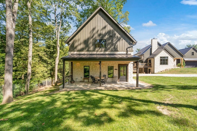 rear view of property with a patio and a lawn