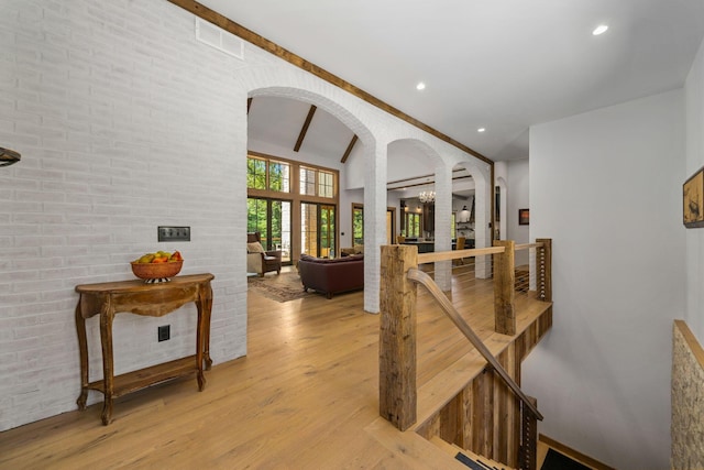 hallway with light hardwood / wood-style floors and brick wall