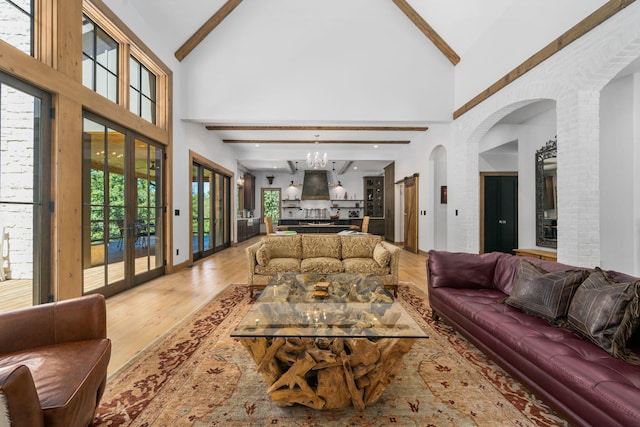 living room featuring beamed ceiling, hardwood / wood-style flooring, high vaulted ceiling, and a wealth of natural light