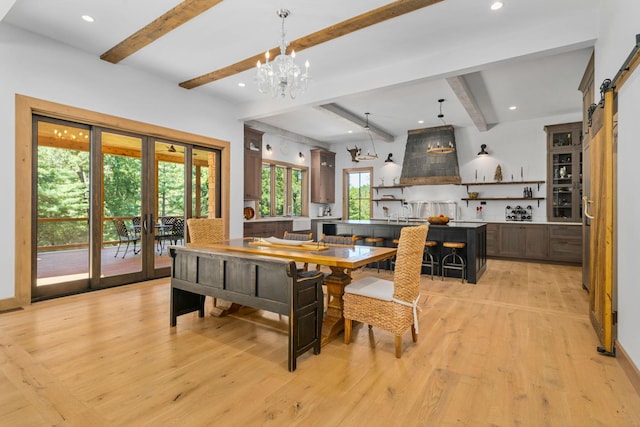 dining room with beam ceiling, a wealth of natural light, and light hardwood / wood-style flooring