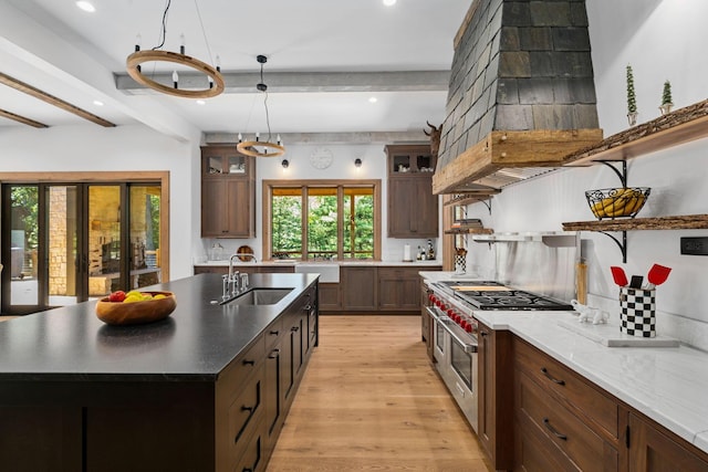 kitchen with pendant lighting, double oven range, sink, and beamed ceiling