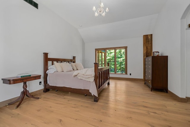 bedroom with a chandelier, light hardwood / wood-style floors, and vaulted ceiling