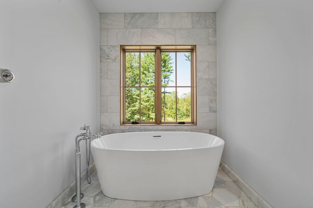 bathroom featuring a bathtub and tile walls