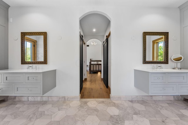 corridor featuring a barn door, plenty of natural light, and sink