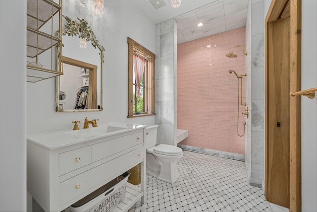 bathroom featuring vanity, toilet, tiled shower, and tile walls