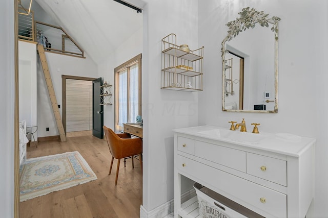 bathroom featuring hardwood / wood-style floors, vanity, and lofted ceiling