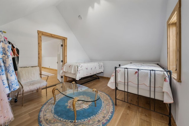 bedroom featuring light hardwood / wood-style floors and vaulted ceiling