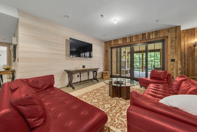 living room featuring french doors and wooden walls